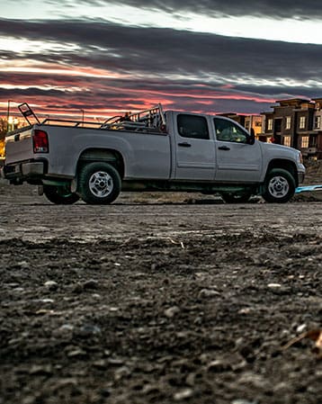 Truck with rebar in the foreground on a construction site at sunset