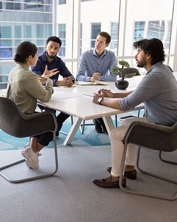 A group of co-workers in a boardroom discussing fleet consulting