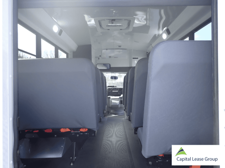 Interior aisle view from the rear of a 12-passenger school activity bus.