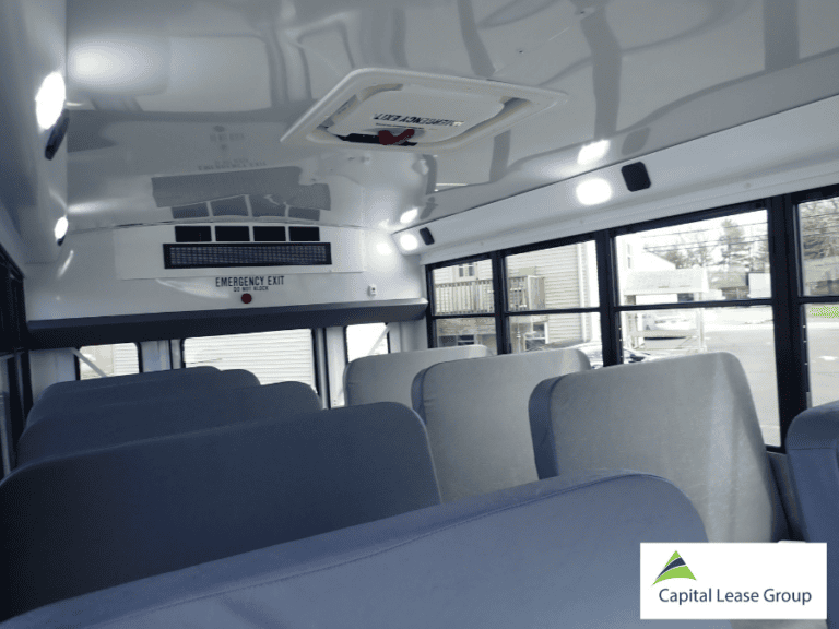 Interior view of school activity bus seating with roof and rear emergency exits.